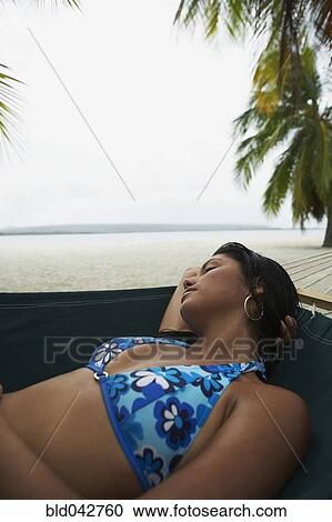 Stock Image - South American woman sleeping in hammock. Fotosearch