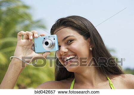 Stock Photo - South American woman taking photograph. Fotosearch