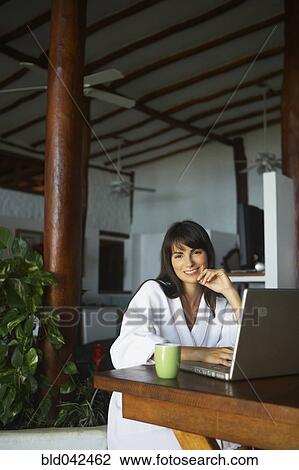 South American woman typing on laptop View Large Photo Image Stock Image - South American woman typing on laptop. Fotosearch