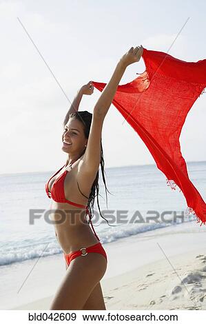 Stock Photo - South American woman walking on beach. Fotosearch