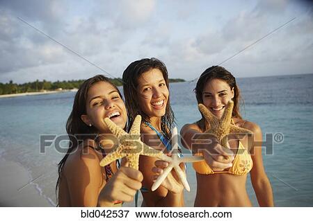 Stock Photo - South American women holding starfish. Fotosearch