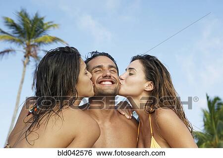 Stock Photograph - South American women kissing man on both cheeks. Fotosearch