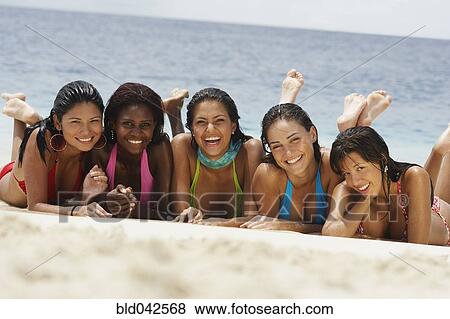Stock Photo - South American women laying on beach. Fotosearch