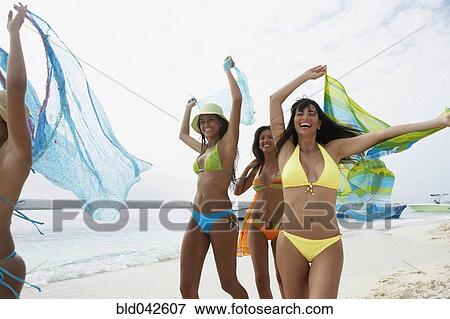 Stock Photo - South American women running on beach. Fotosearch