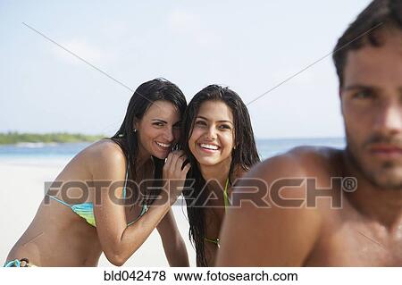South American women whispering behind man View Large Photo Image Stock Photo - South American women whispering behind man. Fotosearch