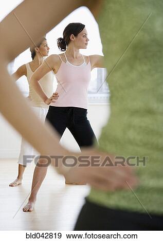 Stock Photo - Three young women in yoga class. Fotosearch