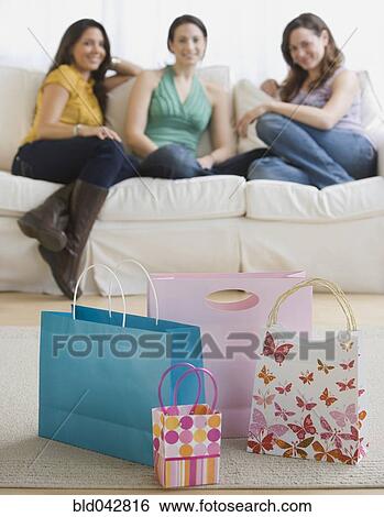 Three young women looking at gift bags View Large Photo Image Stock Photograph - Three young women looking at gift bags. Fotosearch