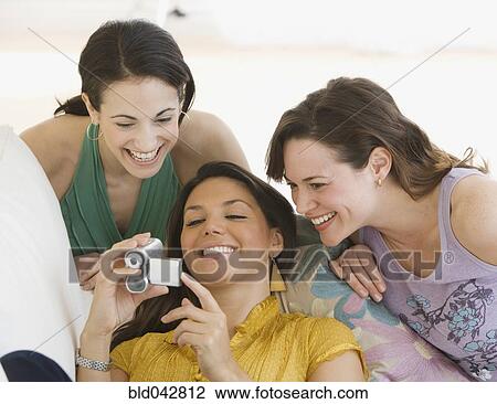 Three young women looking at video camera View Large Photo Image Stock Image - Three young women looking at video camera. Fotosearch