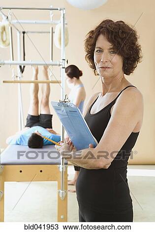 Woman holding clipboard in exercise studio View Large Photo Image Stock Image - Woman holding clipboard in exercise studio. Fotosearch