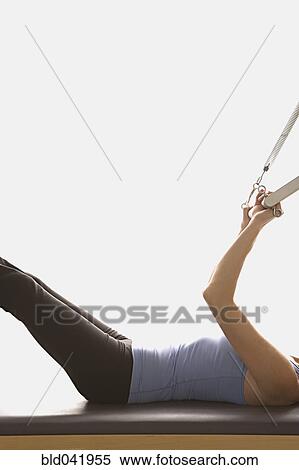 Woman stretching on exercise equipment View Large Photo Image Stock Photography - Woman stretching on exercise equipment. Fotosearch