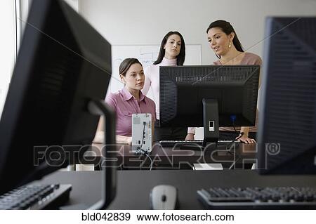 Young businesswomen looking at computer View Large Photo Image Stock Photo - Young businesswomen looking at computer. Fotosearch