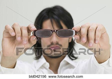 Young Hispanic man holding eyeglasses View Large Photo Image Stock Photograph - Young Hispanic man holding eyeglasses. Fotosearch