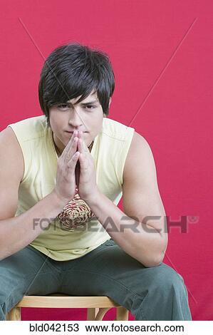 Young Hispanic man sitting in chair View Large Photo Image Stock Image - Young Hispanic man sitting in chair. Fotosearch