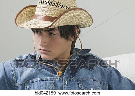 Stock Photo - Young Hispanic man wearing cowboy hat. Fotosearch