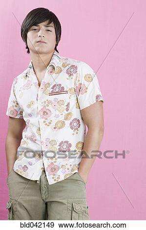 Stock Photo - Young Hispanic man with hands in pockets. Fotosearch