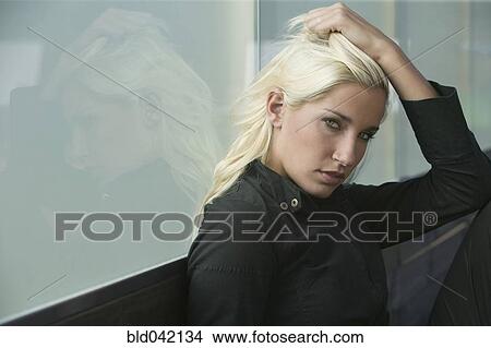 Picture - Young woman with hand in hair. Fotosearch