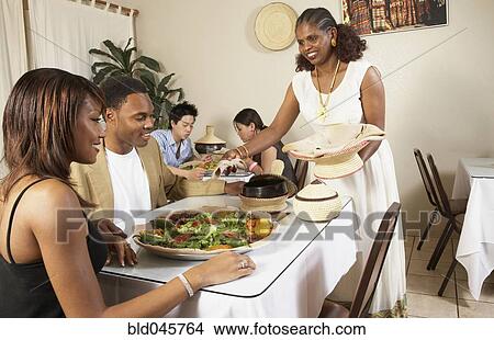 Picture - African American couple eating at restaurant. Fotosearch