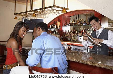 Stock Photograph - African American couple sitting at bar. Fotosearch