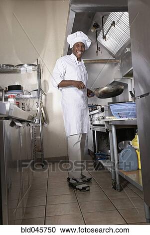 Stock Image - African American male chef in kitchen. Fotosearch