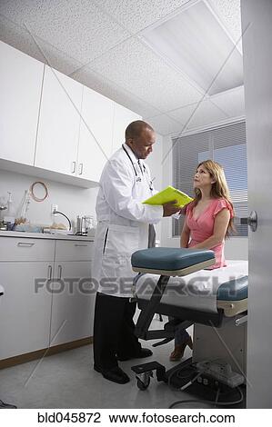 Stock Image - African American male doctor talking to patient. Fotosearch