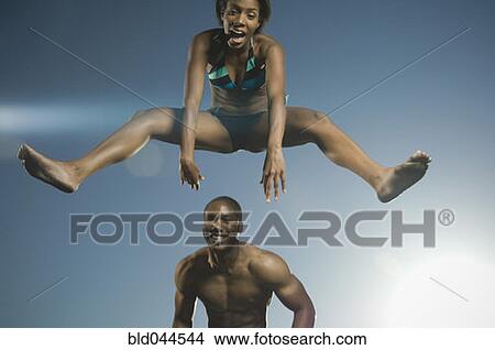 African American woman in bathing suit jumping over man View Large Photo Image Picture - African American woman in bathing suit jumping over man. Fotosearch