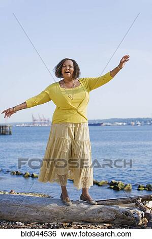 African American woman standing on log View Large Photo Image Stock Photograph - African American woman standing on log. Fotosearch