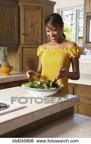 Stock Photograph - African American woman tossing salad. Fotosearch