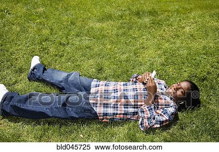 Stock Photography - African boy listening to mp3 player. Fotosearch