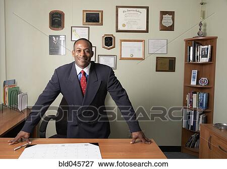 African businessman leaning on desk View Large Photo Image Stock Photo - African businessman leaning on desk. Fotosearch