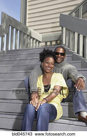 Stock Image - African couple sitting on stairs. Fotosearch
