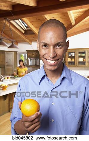 Stock Image - African man holding fruit. Fotosearch