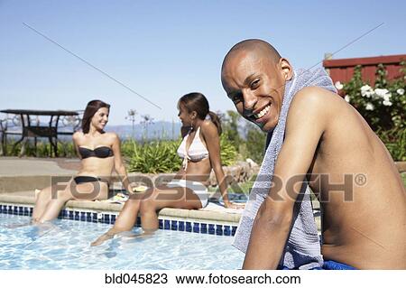 Stock Image - African man next to swimming pool. Fotosearch
