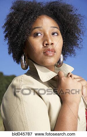 Stock Photo - African woman holding jacket collar. Fotosearch