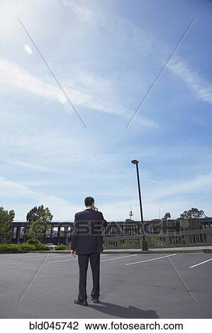 Asian businessman in parking lot View Large Photo Image Stock Image - Asian businessman in parking lot. Fotosearch