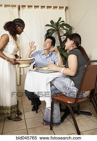 Stock Photography - Asian couple complimenting owner of restaurant. Fotosearch