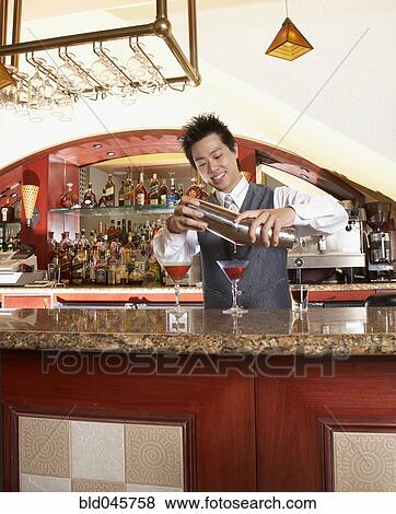 Asian male bartender pouring cocktails View Large Photo Image Stock Photo - Asian male bartender pouring cocktails. Fotosearch