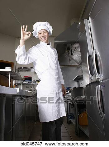 Stock Photo - Asian male chef making OK hand gesture. Fotosearch
