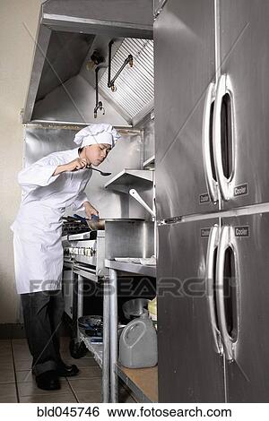 Stock Photograph - Asian male chef tasting food. Fotosearch