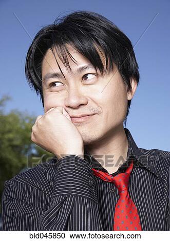Asian man leaning chin on hand View Large Photo Image Stock Image - Asian man leaning chin on hand. Fotosearch