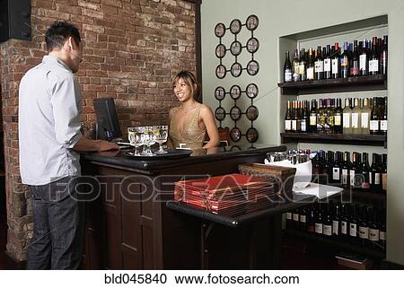 Stock Image - Asian man paying at restaurant. Fotosearch