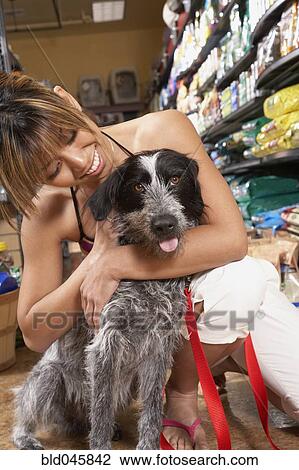 Asian woman hugging dog in pet store View Large Photo Image Stock Image - Asian woman hugging dog in pet store. Fotosearch