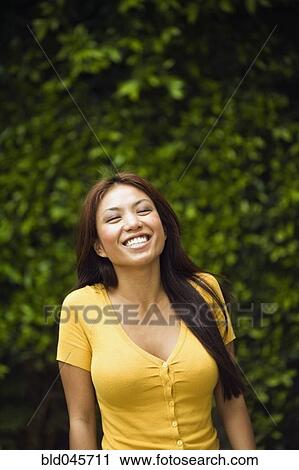 Asian woman laughing outdoors View Large Photo Image Stock Image - Asian woman laughing outdoors. Fotosearch