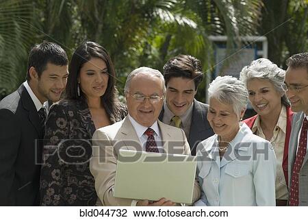 Group of Hispanic businesspeople looking at laptop View Large Photo Image Stock Image - Group of Hispanic businesspeople looking at laptop. Fotosearch