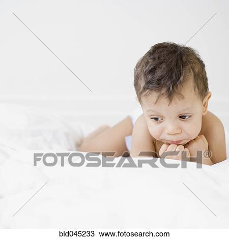 Hispanic baby laying on bed View Large Photo Image Stock Image - Hispanic baby laying on bed. Fotosearch