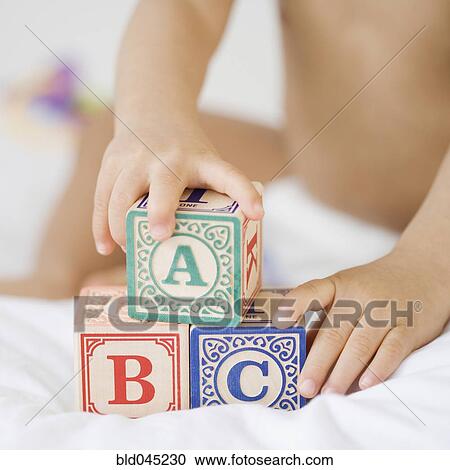 Stock Image - Hispanic baby playing with blocks. Fotosearch