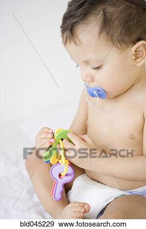 Hispanic baby playing with toy keys View Large Photo Image Stock Photo - Hispanic baby playing with toy keys. Fotosearch