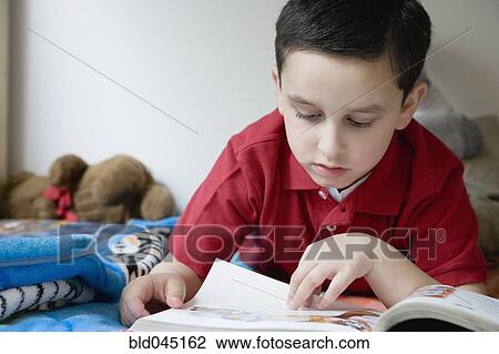 Stock Image - Hispanic boy reading book. Fotosearch