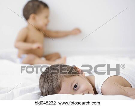 Hispanic brothers playing on bed View Large Photo Image Stock Image - Hispanic brothers playing on bed. Fotosearch