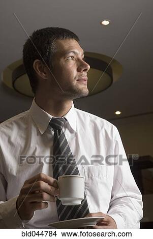 Picture - Hispanic businessman drinking coffee. Fotosearch