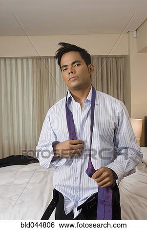 Stock Photograph - Hispanic businessman getting dressed. Fotosearch